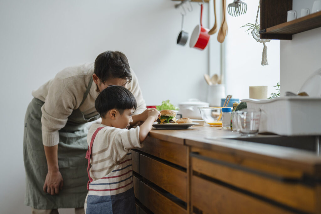 料理をする子どもを見守るお父さん