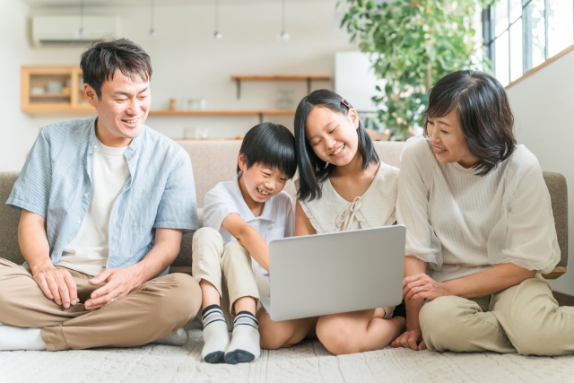 パソコンを眺める家族の写真